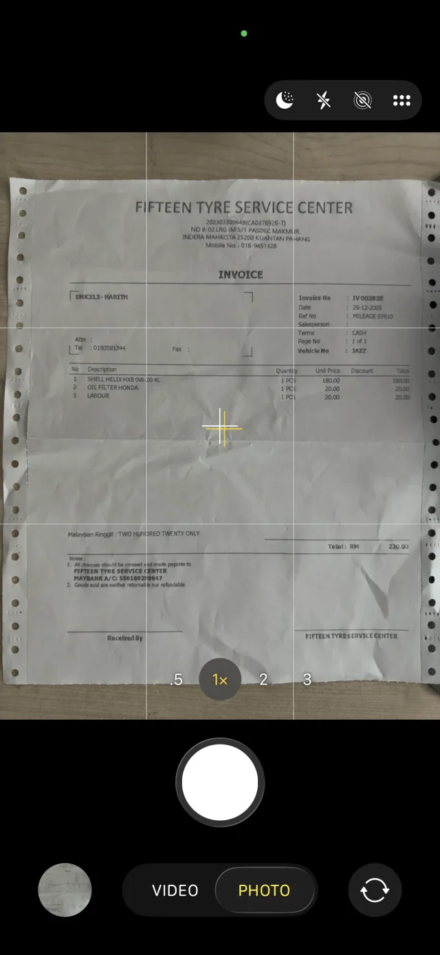 The camera pointed at a printed workshop invoice from Fifteen Tyre Service Center, totalling RM 220.00